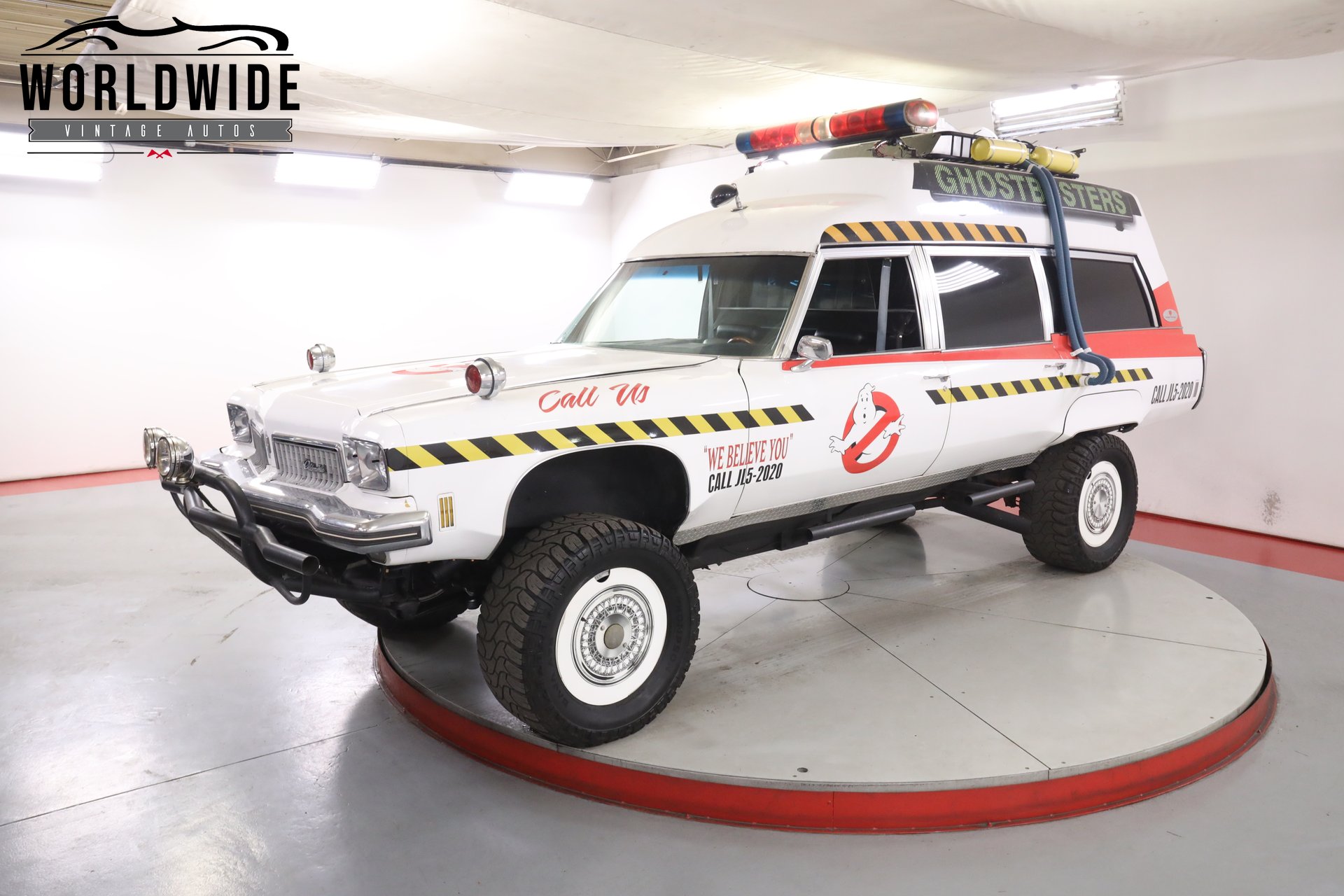 White Ghostbusters-themed Oldsmobile station wagon with roof-mounted props, exact seller exterior view